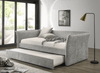 Daybed Yuri tapizado en tela color gris con descansabrazos curvos, cama nido extraída, en ambiente de recámara junto a ventanal - Estylo House Muebleria