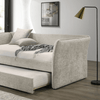Detalle en ángulo del daybed Yuri en tela beige, mostrando el descansabrazos curvo y la cama nido parcialmente extraída - Estylo House Muebleria