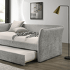 Detalle en ángulo del daybed Yuri en tela gris, mostrando el descansabrazos curvo y la cama nido parcialmente extraída - Estylo House Muebleria