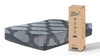 Colchón Gris Hibrido Memory Foam 12" Queen con acabado acolchado en tono gris, junto a su caja de empaque enrollable con la leyenda Sleep Delivered - Estylo House Muebleria